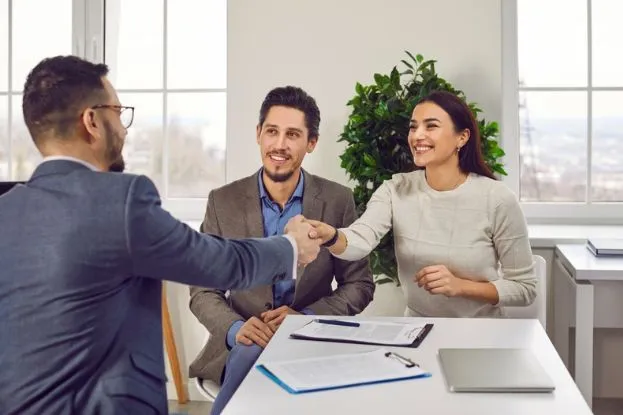 Happy Couple Shaking hands with an Insurance Agent