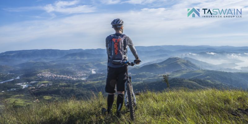 Biker with his cycle on mountain