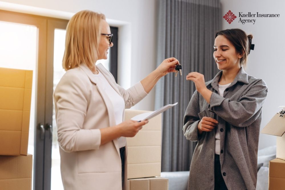 Woman receiving keys from an insurance agent in new home